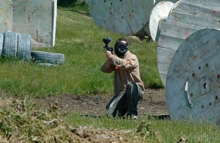 chico en un campo de paintball jugando